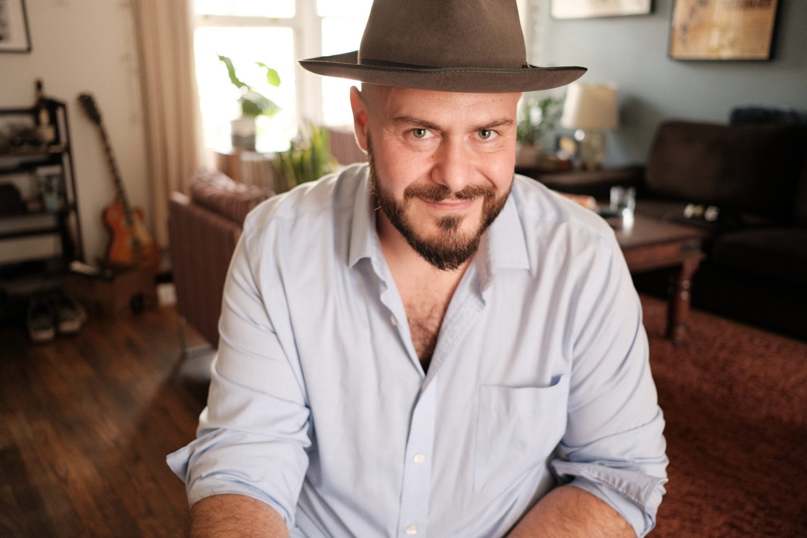 Alessio di Giambattista smiling in a brown fedora and light blue shirt