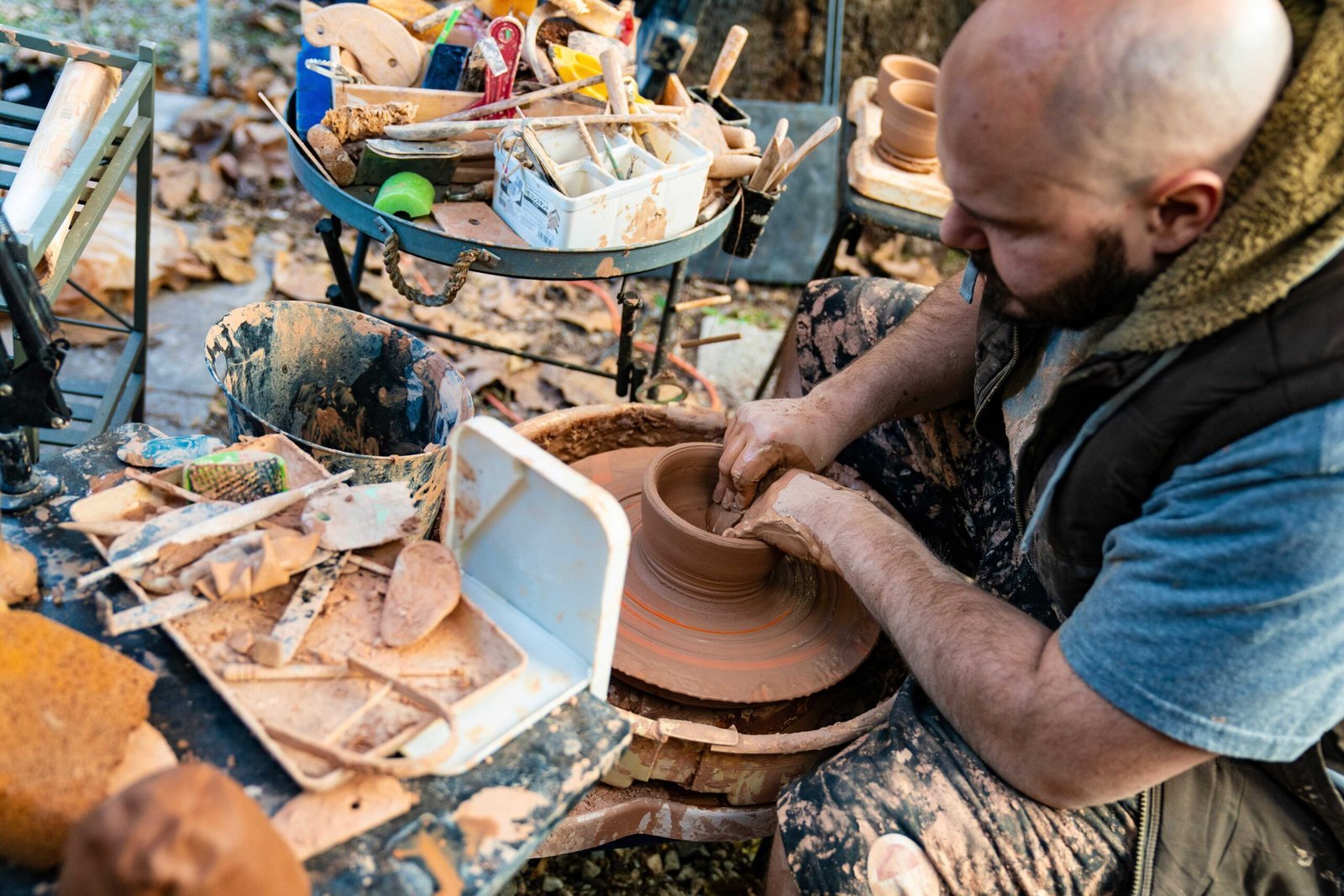 Ceramics Alessio di Giambattista shaping a clay pot on an outdoor pottery wheel
