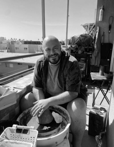 Alessio di Giambattista smiling at a pottery wheel on a sunny balcony