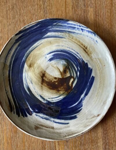Ceramic plate swirled with bold cobalt blue and brown glaze