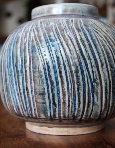 Globe-shaped vase carved with vertical stripes in blue and brown